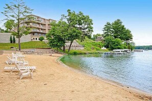 A lakeside hotel with a sandy beach, lounge chairs, and a boat dock. - Beautiful lakefront home w/free WiFi, full kitchen, shared pool & hot tub (Wisconsin Dells)