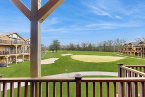 A golf course with a wooden deck and buildings in the background. - Lovely home overlooking golf course with WiFi, AC, pool, hot tub - near lake (Arkdale)