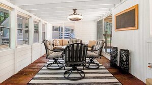 A sunroom with a dining table and chairs, a chandelier, and large windows. - Peaceful 3BR home w/ 3 season clubhouse 1/2 mile from Castle Rock Lake (Mauston)