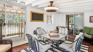 A dining area with a glass table, cushioned chairs, and a ceiling fan. - Peaceful 3BR home w/ 3 season clubhouse 1/2 mile from Castle Rock Lake (Mauston)