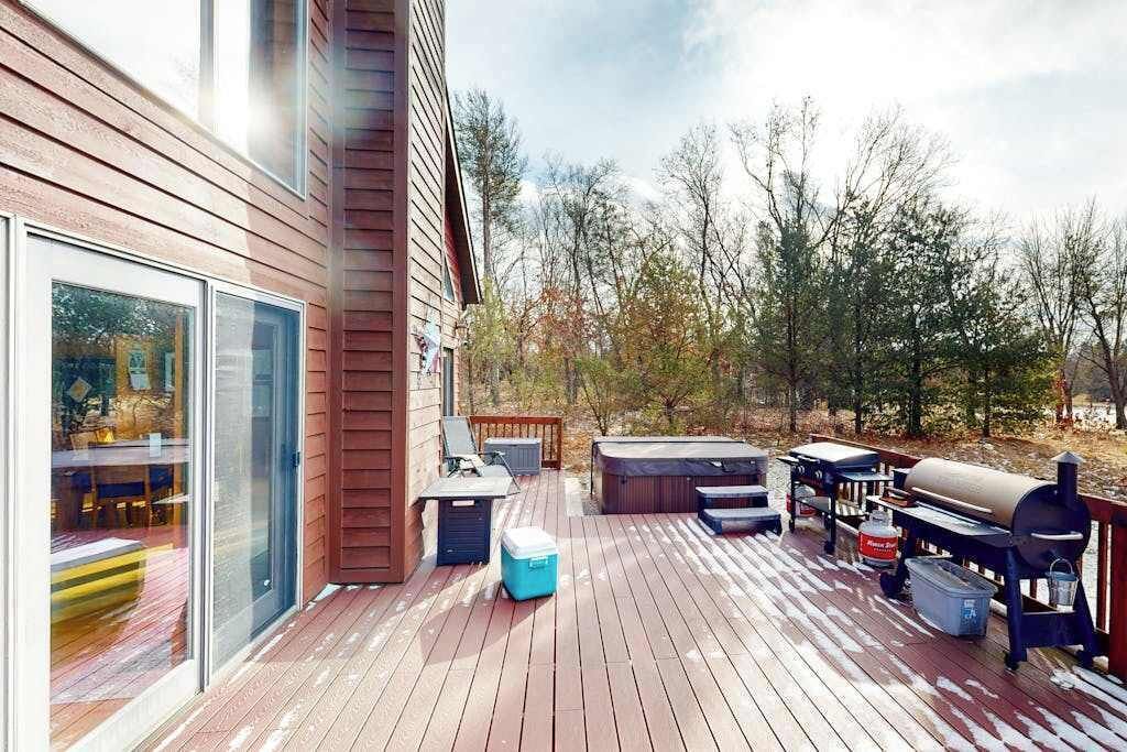 Una terraza con hidromasaje, parrilla y mobiliario exterior.
