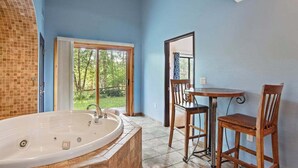A bathroom with a large bathtub, a window, and a view of the outdoors. - Cozy Fireside Condo with Jetted Tub & AC (Wisconsin Dells)