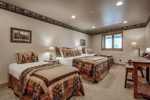 A bedroom with three beds, a desk, and a window. - Lakefront lodge with private dock, firepit, deck & sunset views (Eagle River)