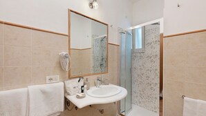 A bathroom with a sink, mirror, towel rack, and shower. - Villevieille Relais – Superior Double Room with Sea View, Wi-Fi & Air Conditioning (Piano di Sorrento)