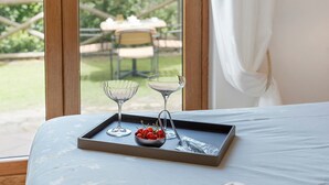 A bed with a tray containing a bowl of cherries, two wine glasses, and a smartphone. - Villevieille Relais – Superior Double Room with Sea View, Wi-Fi & Air Conditioning (Piano di Sorrento)