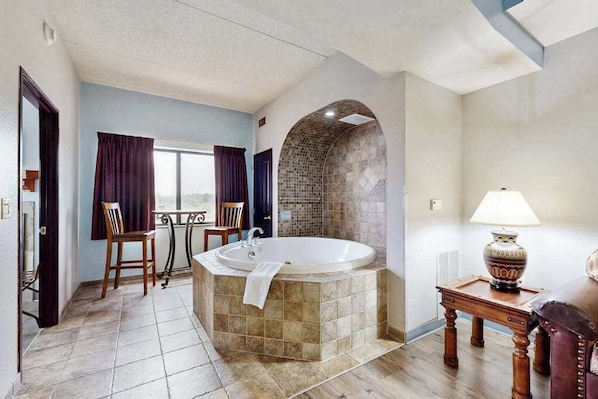 A bathroom with a large bathtub, a window, and a view of the outside. - Resort Comfort Meets Dells Adventure (Wisconsin Dells)