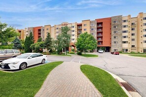 Ein Hotel mit Innenhof, Parkplatz und einem Mehrstöckiger Gebäude mit Balkonen.