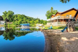 A lakeside cabin with a dock, a boat, and a playground. - Inviting lakefront condo - amazing views, beach access, fireplace, dock, AC, W/D (Wisconsin Dells)