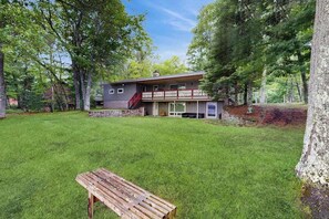 Ett hus med en grund av sten, en träveranda och en röd trappa.