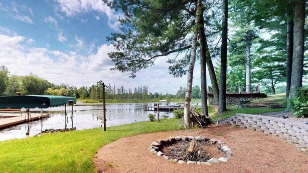 Une propriété au bord du lac, dotée d’un foyer extérieur, d’un quai et d’un espace abrité.