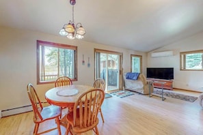 A spacious living area with a dining table, chairs, a sofa, a TV, and a fireplace. - Lakefront home with large patio, fire pit, W/D & WIFI (Woodruff)