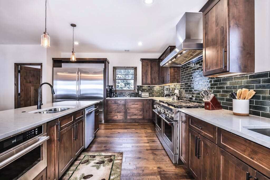 A modern kitchen with stainless steel appliances, wooden cabinets, and a large island.