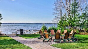 Järvenrantaterassi, jossa on Adirondack-tyyliset puutarhatuolit ja kivestä tehty polku.