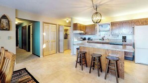 Une cuisine moderne dotée d’un îlot central, de meubles en bois et d’un lustre.