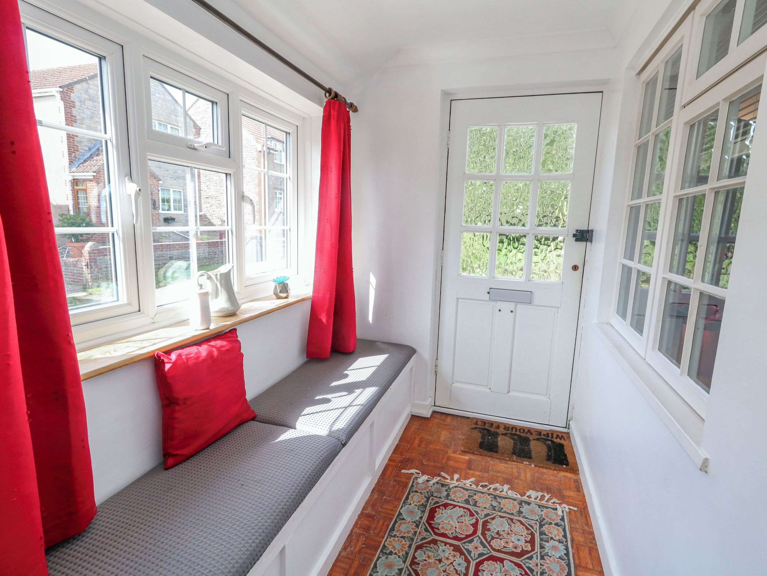 Een kamer met een bank, een deur en ramen.