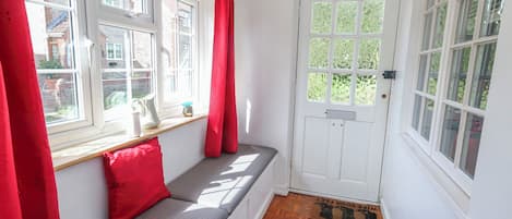 A room with a bench, a door, and windows.
