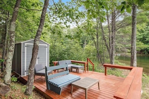 A deck with outdoor furniture, a shed, and a lake view. - Lakefront, Dog-Friendly Cabin with Lake View, Central AC, Dock, Deck, Free WiFi (Minocqua)