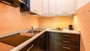 Eine Küche mit einem Doppelwaschbecken, dunklen Holzschränken und einer gefliesten Spritzschutzwand.