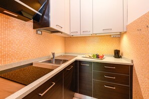 A kitchen with a double sink, dark wooden cabinets, and a tiled backsplash. - MGH - My Lakeview Escape (Peschiera del Garda)