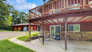 A lodge with a covered patio, stone walls, and a wooden deck. - Cozy wooded duplex w/ WiFi, full kitchen, shared W/D & near lakes & trails (Arkdale)