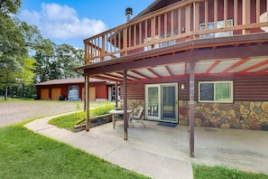 A lodge with a covered patio, stone walls, and a wooden deck. - Cozy wooded duplex w/ WiFi, full kitchen, shared W/D & near lakes & trails (Arkdale)