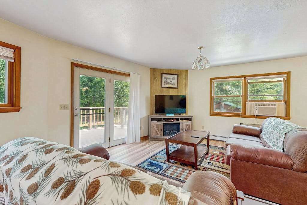 A living room with a sofa, a coffee table, a TV, and a fireplace.