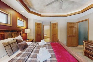 A hotel room with a bed, a nightstand, a lamp, a ceiling fan, and wooden doors. - Lakefront home with  grill, firepit, pool table, & jetted tub (Friendship)