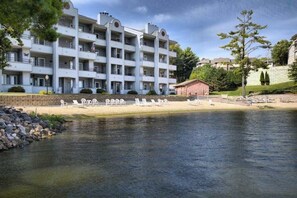 Un hôtel à plusieurs étages doté de balcons, d’un espace piscine avec des chaises longues et d’un petit bâtiment attenant à la piscine.