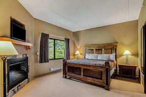 A bedroom with a bed, a television, a fireplace, and a window with curtains. - Family Getaway at Chula Vista Discount Perks (Wisconsin Dells)