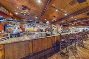 A bar area with a wooden ceiling, bar stools, and a counter with glasses and plates. - Resort Condo with Discount Adventure Perks in the Dells (Wisconsin Dells)