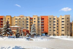 A multi-story hotel with a stone facade, balconies, and a parking area. - Dells Resort Retreat w/ Adventure Included (Wisconsin Dells)