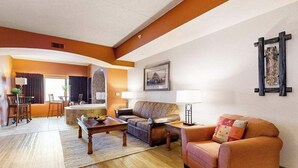 Ein Wohnzimmer mit Sofa, Couchtisch, Lampe und einem Gemälde an der Wand.