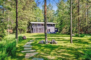 A cabin with a stone pathway leading to it, surrounded by trees.