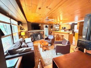 A cozy cabin interior with a fireplace, seating area, and a kitchen. - Blue Jay Cabin | Lakefront cabin in Rhinelander with dock & row boat (Rhinelander)