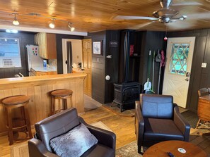 A cozy living area with a bar, leather sofas, and a fireplace.