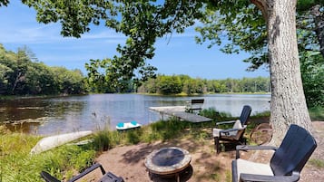 Un cadre idyllique au bord du lac, avec un quai, des chaises et un foyer.