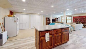 Amplia sala de estar con un mueble grande de madera, techo blanco y un rincón de asientos acogedor.