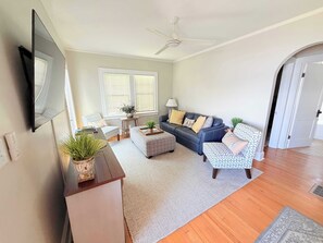 A living room with a sofa, chairs, a coffee table, a TV, and a ceiling fan. - 3-story lakefront home near downtown with lake & dock access, washer/dryer, deck (Minocqua)