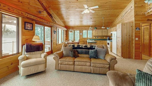 Interior acogedor de una cabaña con sofá, sillón y comedor.