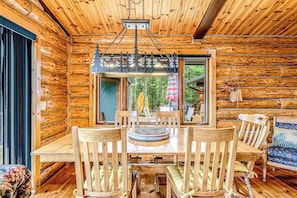 A wooden interior with a dining table, chairs, and a hanging light fixture. - Lakefront log cabin on 3.5 acres with dock, gazebo & sunset views - dog-friendly (Lac Du Flambeau)