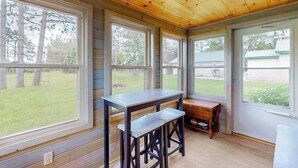 Ein Zimmer mit großen Fenstern, einer Holzbalkendecke und einer Sitzbank.