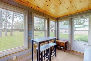 A room with large windows, a wooden ceiling, and a bench. - Cozy home located near Lakes & Trails equipped with WIFI & a Gas Grill (Mercer)