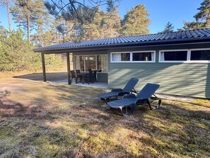 A covered patio with outdoor furniture, a dining area, and a building with a tiled roof. - 5 Person Holiday Home in Aakirkeby (Akirkeby)