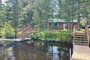 A wooden dock leading to a cabin surrounded by dense forest. - Cozy Cabin located on the Turtle Flambeau Flowage, great for all seasons! (Mercer)