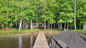 A wooden dock leading to a house surrounded by trees. - Fantastic lakefront home with fireplace, fast WiFi, washer/dryer & dog-friendly (Manitowish Waters)