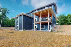 A modern two-story house with a covered porch and a stone retaining wall. - Modern Northwoods Townhouse near lakes, trails & town‚Äîperfect for adventures! (Eagle River)