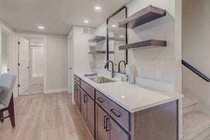 A modern kitchen with a large island, dark cabinetry, and a built-in oven. - Modern Northwoods Townhouse near lakes, trails & town‚Äîperfect for adventures! (Eagle River)