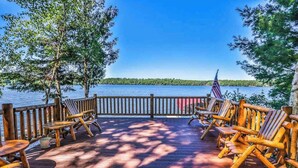 A wooden deck with Adirondack chairs and a view of a lake. - Lakefront retreat with two full kitchens, fireplaces, washer/dryer, & two docks (Eagle River)