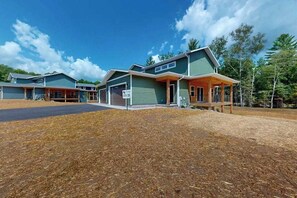 A row of modern houses with a covered porch, a driveway, and a sign indicating 'LOT 35'. - Modern Northwoods Townhouse near lakes, trails & town‚ perfect for adventures! (Eagle River)