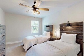 A bedroom with two beds, a ceiling fan, a nightstand, and a dresser. - Modern Northwoods Townhouse near lakes, trails & town‚ perfect for adventures! (Eagle River)